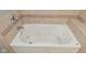 Jetted tub with decorative tile surround in the bathroom at 1702 Kessler Blvd E Dr, Indianapolis, IN 46220