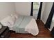 Cozy bedroom features neutral walls and hardwood floors with ample natural light at 1702 Kessler Blvd E Dr, Indianapolis, IN 46220