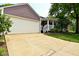 Home with a spacious garage and front porch with hanging baskets creating a welcoming exterior at 1702 Kessler Blvd E Dr, Indianapolis, IN 46220