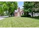 Traditional style home featuring brick and stone accents, lush lawn and mature shade trees at 1702 Kessler Blvd E Dr, Indianapolis, IN 46220