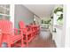 Inviting front porch with red Adirondack chairs and a charming porch swing at 1702 Kessler Blvd E Dr, Indianapolis, IN 46220