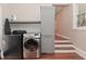 Updated laundry room features gray washer, dryer, storage, and wood floors at 1702 Kessler Blvd E Dr, Indianapolis, IN 46220