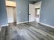 A bright bedroom features an open closet, gray wood floors and fresh blue paint at 1818 Broadway St, Anderson, IN 46012
