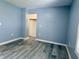 A freshly painted blue bedroom features light-colored vinyl plank flooring and a closet at 1818 Broadway St, Anderson, IN 46012