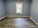 This freshly painted bedroom features modern vinyl plank flooring and a single window at 1818 Broadway St, Anderson, IN 46012