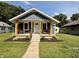 Charming home featuring a cozy front porch, fresh landscaping, and a well-maintained lawn at 1818 Broadway St, Anderson, IN 46012