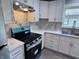 A modern kitchen features white cabinetry, a stainless steel range hood, and gray marble-patterned backsplash and countertops at 1818 Broadway St, Anderson, IN 46012