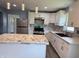 Bright and airy kitchen boasts white cabinets, marble countertops, and modern pendant lighting at 1818 Broadway St, Anderson, IN 46012