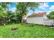 Large backyard with green grass, mature tree, detached garage and fence at 1904 N Bosart Ave, Indianapolis, IN 46218