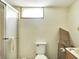 Bathroom with a shower glass door, toilet, and small window at 1904 N Bosart Ave, Indianapolis, IN 46218