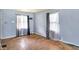 Well-lit living room featuring hardwood floors and windows dressed with patterned curtains at 1904 N Bosart Ave, Indianapolis, IN 46218