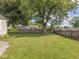 Expansive backyard featuring a mature tree, lush lawn, and wood fence at 2018 N Rochester Ave, Indianapolis, IN 46222