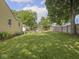Large backyard with an outdoor seating area, privacy fence, and mature trees at 2018 N Rochester Ave, Indianapolis, IN 46222