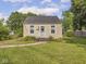 Cozy single-story home featuring a manicured lawn, sidewalk and mature trees at 2018 N Rochester Ave, Indianapolis, IN 46222