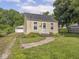 Charming yellow home featuring a well-maintained lawn, walkway, and a detached garage at 2018 N Rochester Ave, Indianapolis, IN 46222