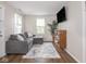 Cozy living room featuring a plush gray couch, a large TV, and natural lighting at 2018 N Rochester Ave, Indianapolis, IN 46222