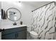 Bathroom featuring modern vanity, round mirror, and shower with patterned curtain at 205 Poplar St, Westfield, IN 46074