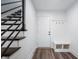 Inviting entryway with modern staircase, hall tree with bench and coat hooks, and hardwood flooring at 205 Poplar St, Westfield, IN 46074