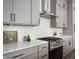 Modern kitchen featuring gray cabinets, stainless steel range hood, and white subway tile backsplash at 205 Poplar St, Westfield, IN 46074