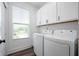 Bright laundry room featuring white cabinets, washer and dryer, and natural light from a window at 205 Poplar St, Westfield, IN 46074