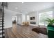 Bright, open living room with modern fireplace, hardwood floors, and staircase at 205 Poplar St, Westfield, IN 46074