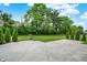 A backyard featuring a concrete patio with green grass, bushes, and trees surrounding the perimeter at 2074 Tompkins Dr, Westfield, IN 46074