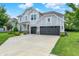 Two-story home with a three-car garage, a well-manicured lawn, and beautiful landscaping at 2074 Tompkins Dr, Westfield, IN 46074