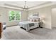Spacious main bedroom with tray ceiling, chandelier, and large window, providing a bright and airy ambiance at 2074 Tompkins Dr, Westfield, IN 46074