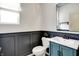 Stylish powder room with gray wainscoting, blue vanity, and modern fixtures, creating a sophisticated and inviting space at 2074 Tompkins Dr, Westfield, IN 46074