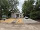 Inviting home with gray siding, a covered porch, and a gravel driveway, surrounded by mature trees at 2127 Haines Ave, Indianapolis, IN 46221