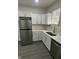 Beautifully designed kitchen with stainless steel refrigerator, tiled backsplash and modern white cabinetry at 2127 Haines Ave, Indianapolis, IN 46221