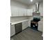 Updated kitchen boasts new stainless steel appliances, white cabinets, and a modern vent hood at 2127 Haines Ave, Indianapolis, IN 46221