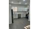 Modern kitchen boasting white cabinets, stainless steel appliances, and sleek gray flooring at 2127 Haines Ave, Indianapolis, IN 46221
