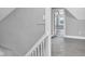 Hallway with neutral walls and carpet, white banister, and view into the adjacent bedroom at 247 N 14Th St, Noblesville, IN 46060