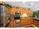 Bright kitchen with oak cabinetry, stainless steel appliances, and a decorative backsplash at 255 Bastion Pl # Apt D, Avon, IN 46123