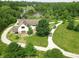 Aerial view of a cream colored home with a private drive and pond surrounded by lush greenery and mature trees at 2825 E 216Th St, Cicero, IN 46034