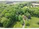 An aerial shot showcases the property's greenery and a paved driveway that leads to a large expanse of trees at 2825 E 216Th St, Cicero, IN 46034