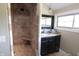 Well-lit bathroom with stone tiled shower, vanity sink, and a decorative mirror at 2825 E 216Th St, Cicero, IN 46034