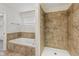 Bright bathroom featuring a white tub with tile surround and a walk-in shower at 3430 Whalen Ave, Indianapolis, IN 46227