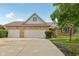 Brick home featuring a three-car garage, well-maintained lawn and beautiful, mature tree at 3430 Whalen Ave, Indianapolis, IN 46227