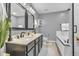 Well-lit bathroom with double sink vanity, framed mirrors, and a separate tub with tile accents at 3637 Newberry Rd, Plainfield, IN 46168