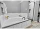 Bright bathroom featuring a corner soaking tub, glass enclosed shower with black hardware, and wainscoting at 3637 Newberry Rd, Plainfield, IN 46168