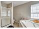 Bathroom featuring a glass shower and a soaking tub under a window at 3816 Cologne Ct, Indianapolis, IN 46228
