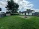Spacious backyard with green grass, privacy fence, storage shed, patio, and a fire pit for outdoor entertaining at 39 Meadow Creek East Blvd, Whiteland, IN 46184