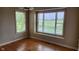 Sun-filled bedroom with hardwood floors and two large windows overlooking a manicured lawn at 4230 Raintree Blvd, Greenwood, IN 46143