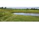 Scenic view of a lush golf course with a pond, rolling hills and manicured greens at 4230 Raintree Blvd, Greenwood, IN 46143
