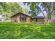 Backyard featuring a brick house, a grassy lawn, and mature trees at 436 N 500 W, Anderson, IN 46011