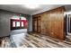 Spacious living room showcasing hardwood floors, paneling, and a view into an adjacent room at 436 N 500 W, Anderson, IN 46011