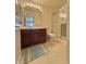 Clean bathroom features vanity with dark cabinetry, framed mirror, and shower with glass door at 5019 Amber Creek Pl, Indianapolis, IN 46237