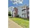 Multi-story condo building with balconies, red brick accents, and a lush green lawn at 5019 Amber Creek Pl, Indianapolis, IN 46237